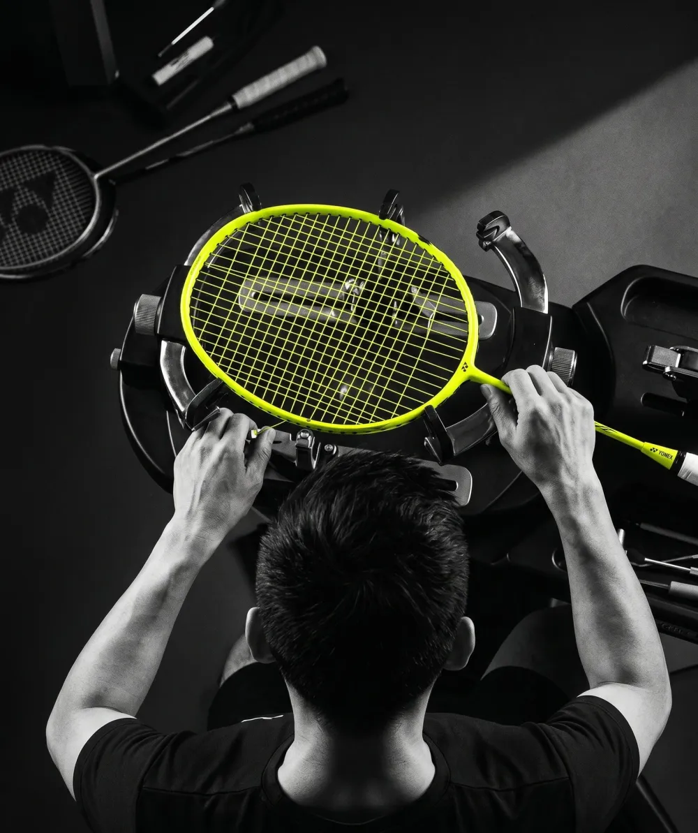 Mickael au cordage d'une raquette de badminton